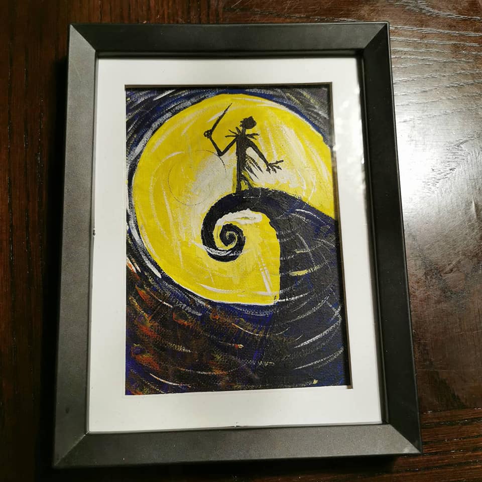 ramed painting of Jack Skellington silhouette on spiral hill against large yellow moon.