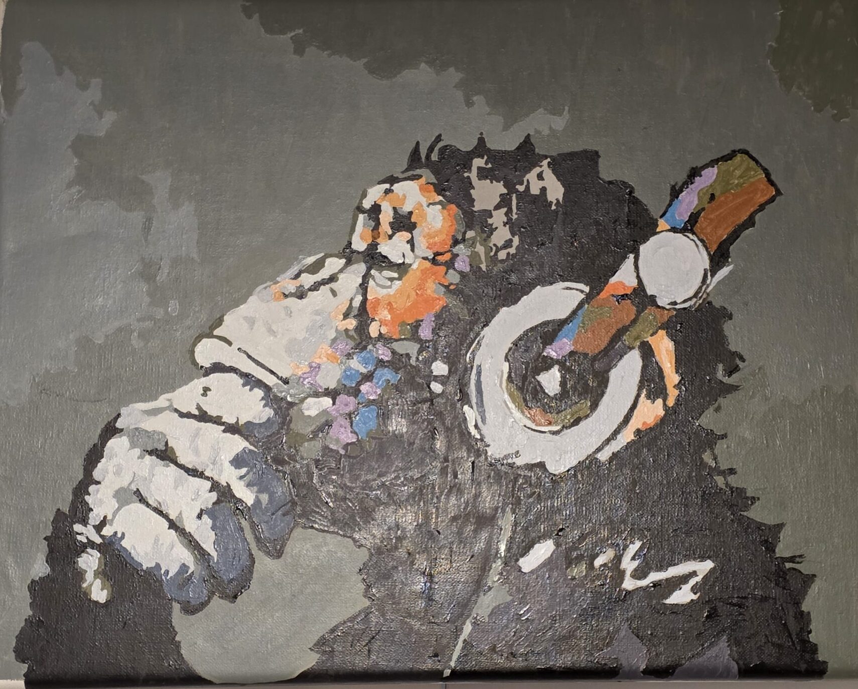 Ape listening to music with headphones with on hand resting on chin.